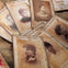 A collection of old sepia-toned portrait cards labeled "Scotland Yard London" spread out on a cloth surface.