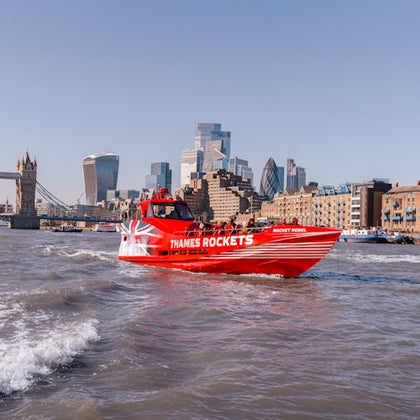 A red speedboat labeled "Thames Rockets" travels on the River Thames in London, with city landmarks in the background.