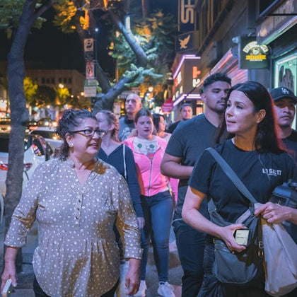 Tour group walking between locations as they listen to their guide tell stories of the city