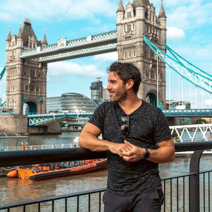 A tourist is having his photo taken outside the Tower Bridge.