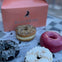 Four assorted doughnuts on Blackbird-branded paper in front of a pink box with the Blackbird logo.