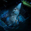 Three divers explore a sunken shipwreck illuminated by a yellow submarine’s spotlight underwater.