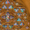 A close-up view of a cathedral's rose window with intricate stained glass and ornate stone tracery.