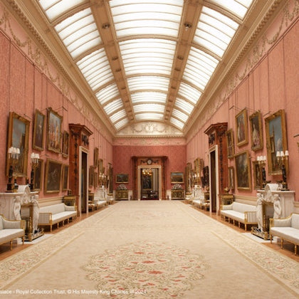 A grand, ornate hall with high ceilings, numerous framed paintings, elegant sofas, and a patterned carpet running the length of the room.