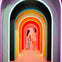 Two women standing under a series of colorful, illuminated archways, facing and smiling at each other.