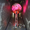 Visitors ascending a red-lit escalator into a large globe structure inside a dark exhibition hall with constellation murals.