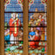 A stained glass window depicting a religious scene with figures in colorful robes and architectural details.