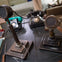Two vintage microphones and telephones are on a desk in a retro office setting.