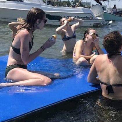 Amigos comparten risas y disfrutan de bebidas animadas: una imagen vibrante de amistad despreocupada en el agua.