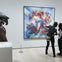 Three people observe an abstract painting in a museum gallery, with a sculpture visible on the left in the foreground.