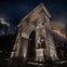 Nighttime photo of the Washington Square Park in New York with lightning striking the sky